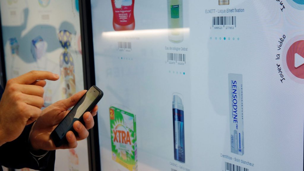 Head Of Innovation at Groupe Casino, uses his mobile phone at the digital wall to select the items as he shops inside a high-tech store named "Le 4 Casino" in Paris, France, October 4, 2018