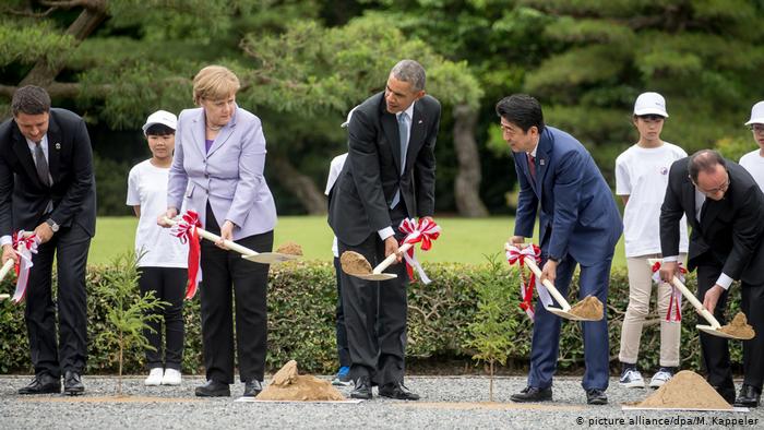 La chancelière allemande Angela Merkel plante un arbre à Ise-Shima, au Japon, à côté de l'ancien président américain Barack Obama
